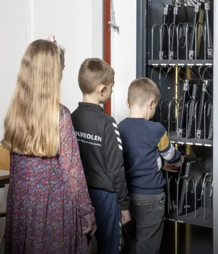 børn foran pc-skab på skole