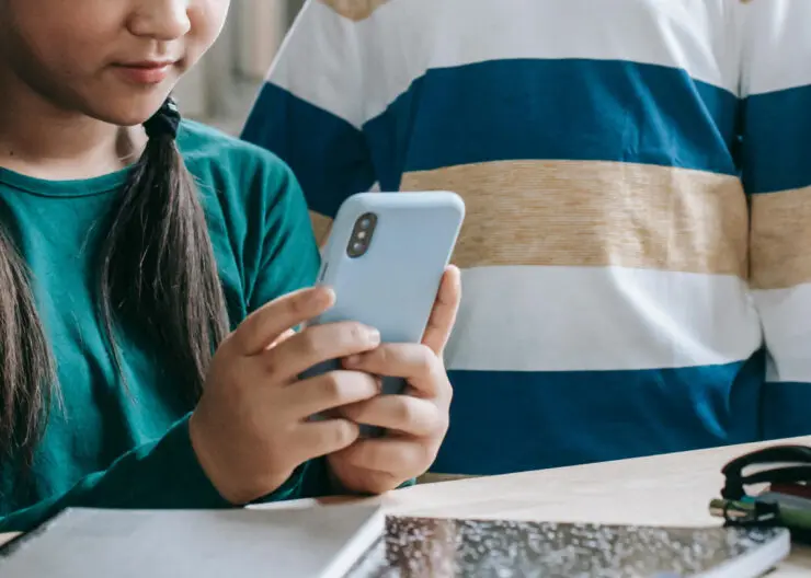 to elever ser på en mobiltelefon i skolen